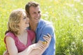 Couple sitting outdoors holding flower smiling Royalty Free Stock Photo