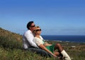 Couple sitting outdoors holding flower smiling Royalty Free Stock Photo