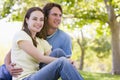 Couple sitting outdoors smiling Royalty Free Stock Photo