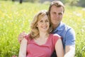 Couple sitting outdoors smiling Royalty Free Stock Photo