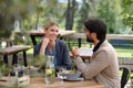 Couple sitting outdoors on terrace restaurant, having dinner date. Business lunch for two managers, discussing new Royalty Free Stock Photo