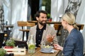 Couple sitting outdoors on terrace restaurant, having dinner date. Business lunch for two managers, discussing new Royalty Free Stock Photo