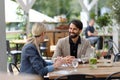 Couple sitting outdoors on terrace restaurant, having dinner date. Business lunch for two managers, discussing new Royalty Free Stock Photo