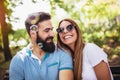 Couple sitting on the park bench and blowing soup bubbles on beautiful day Royalty Free Stock Photo