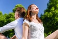 Couple sitting on park lawn enjoying sun Royalty Free Stock Photo