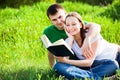 Couple sitting in park reading book Royalty Free Stock Photo