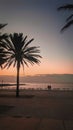 Couple sitting in playa de bogatell beach in Barcelona for a morning sunrise. Royalty Free Stock Photo
