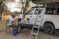 couple sitting in portable chairs drinking tea talking. camping summer activities