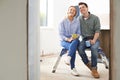 Couple Sitting In Property Being Renovated