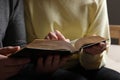 Couple sitting and reading holy Bible indoors, closeup Royalty Free Stock Photo