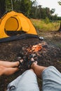couple sitting resting near camping fire yellow tent on background Royalty Free Stock Photo