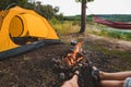 couple sitting resting near camping fire yellow tent on background Royalty Free Stock Photo