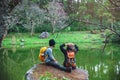 Couple sitting on rocks and taking pictures nature, flowers. at Paphiopedilum orchid conservation center Royalty Free Stock Photo