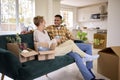 Couple Sitting On Sofa Unpacking Boxes After Moving Into New Home Together Royalty Free Stock Photo