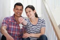 Young Couple Sitting On Stairs Holding Keys To New Home Royalty Free Stock Photo