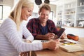 Couple sitting in their kitchen using laptop Royalty Free Stock Photo