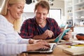 Couple sitting in their kitchen using laptop Royalty Free Stock Photo