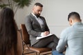 Couple sitting at therapy session with therapist, man taking notes Royalty Free Stock Photo