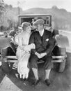 Couple sitting together on a car bumper