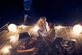 couple sitting together on a water dock at beautiful moon at night Royalty Free Stock Photo