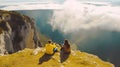 Couple sitting on top of a mountain and looking at the beautiful view. Generative AI Royalty Free Stock Photo