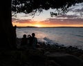 Couple Sitting Under a Tree Taking Picture to the Sunset in Noosa, Queensland, Australia Royalty Free Stock Photo