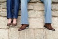 Couple sitting on wall feet only