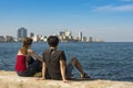 Couple sitting on wall at Malecon Havana