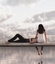 Couple sitting on wooden fence looking to sky