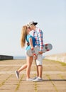 Couple with skateboard kissing outdoors