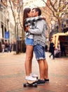 Couple, skateboarding and kissing in city, in love and excited to learn together and romantic relationship. Cape town