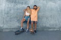 Couple With Skateboards Portrait. Guy And Girl In Casual Outfit Against Concrete Wall At Skatepark Royalty Free Stock Photo