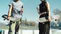 Couple of skaters holding their skateboards and drinking water in the park Royalty Free Stock Photo