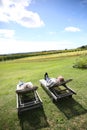 Couple sleeping outdoor on long chairs