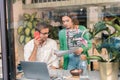 Couple of smart entrepreneurs working in cozy cafeteria together