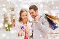 Couple with smartphone and shopping bags in mall Royalty Free Stock Photo
