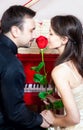 Couple smelling rose near red piano