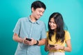 Couple smile standing wear shirt, excited young couple holding mobile phones looking Royalty Free Stock Photo