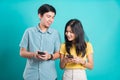 Couple smile standing wear shirt, excited young couple holding mobile phones looking Royalty Free Stock Photo