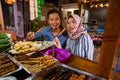 couple smiling at camera having dinner out at traditional food stall Royalty Free Stock Photo