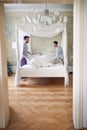 Couple smiling, laughing while making bed together in the morning in modern bedroom. couple, togetherness, morning, concept