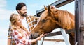 couple of smiling ranchers palming horse Royalty Free Stock Photo