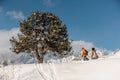 Couple of snowboarders in sportswear climbing the mountain