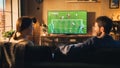 Couple of Soccer Fans Relax on a Couch, Watch a Sports Match at Home in Stylish Loft Apartment Royalty Free Stock Photo