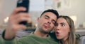 Couple, sofa and selfie with funny face in home living room with cross eyes, tongue and together for web blog. Man Royalty Free Stock Photo