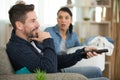 couple on sofa with tv remote