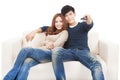 Couple on sofa watching TV with remote control Royalty Free Stock Photo