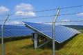 Couple of solar panel fenced in a rusty barbed wire Royalty Free Stock Photo