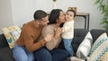 Couple and son hugging each other sitting on sofa at home Royalty Free Stock Photo