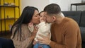 Couple and son kissing and hugging each other sitting on floor at home Royalty Free Stock Photo